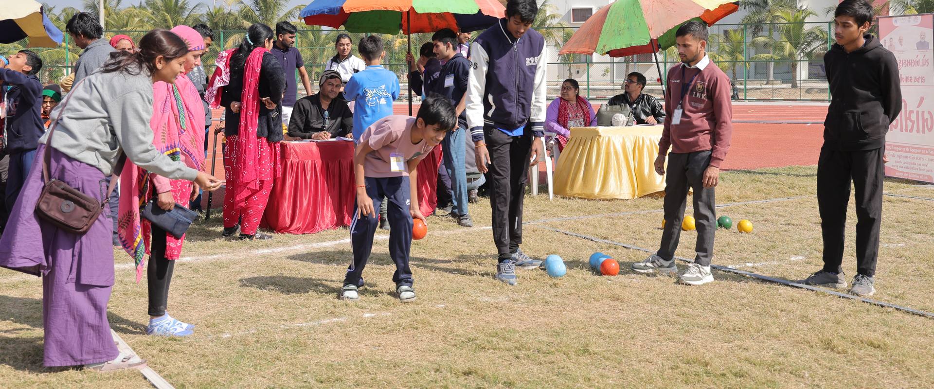 Athletes playing boccia on the grass at the Special Khel Mahakumbh 2025 state-level competition, Porbandar