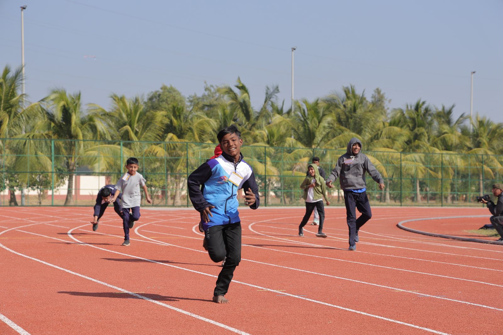 A smiling athlete runs towards the finish