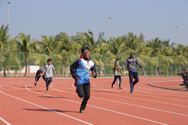 A smiling athlete runs towards the finish